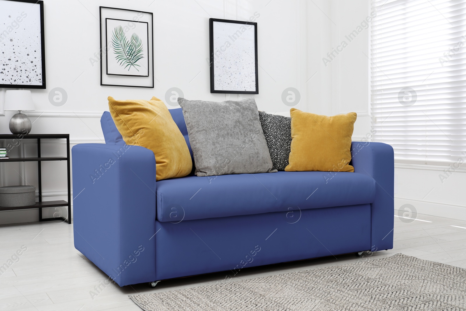 Image of Living room with blue sofa and pillows. Interior design