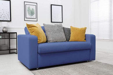 Image of Living room with blue sofa and pillows. Interior design
