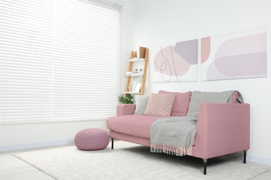 Image of Living room with pink sofa and other furniture. Interior design