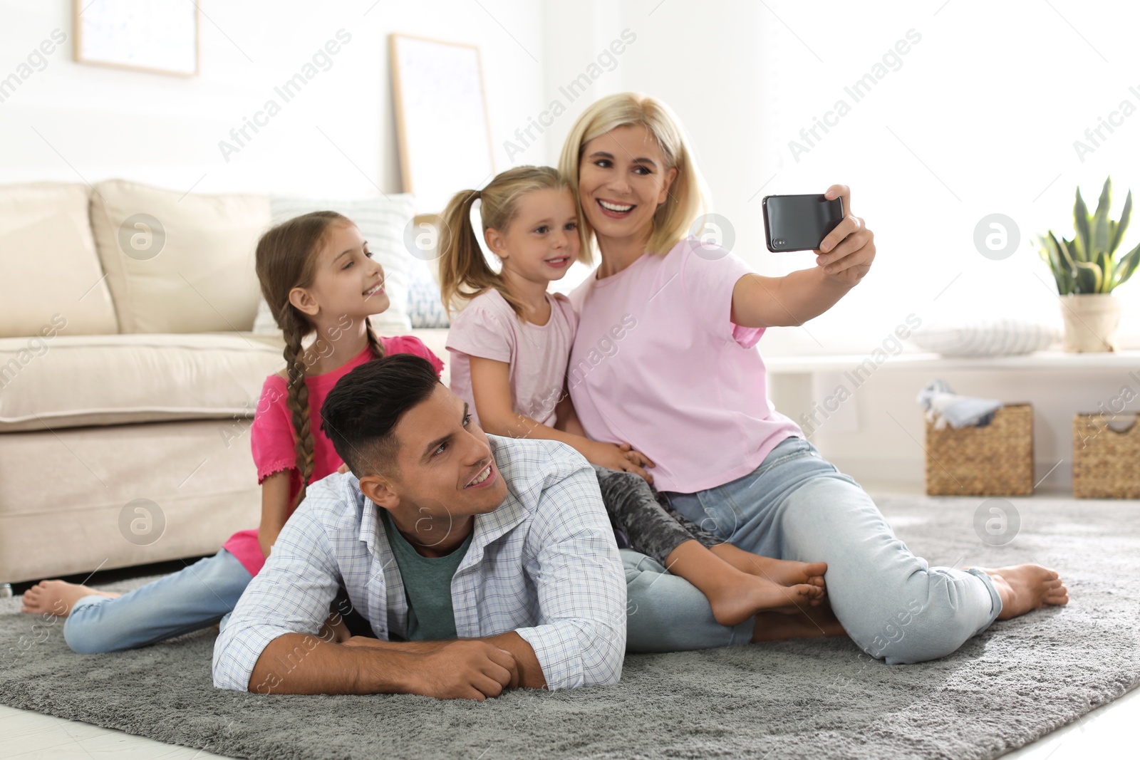 Photo of Happy family taking selfie on floor at home