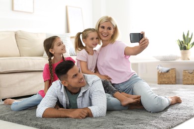 Photo of Happy family taking selfie on floor at home