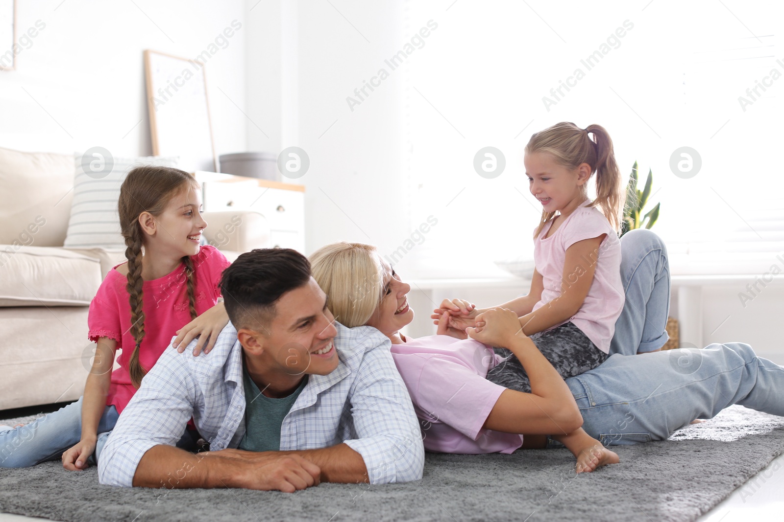 Photo of Happy family with children on floor at home