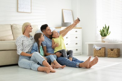 Photo of Happy family taking selfie on floor at home