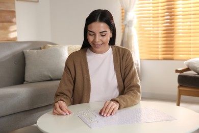 Photo of Young woman playing with puzzles at home
