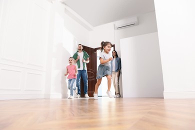 Photo of Happy family in their new house on moving day, low angle view