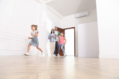 Photo of Happy family in their new house on moving day, low angle view