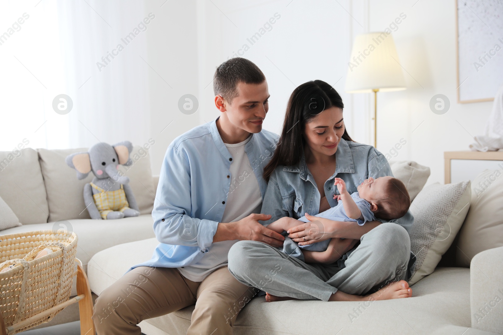 Photo of Happy family with cute baby on sofa at home