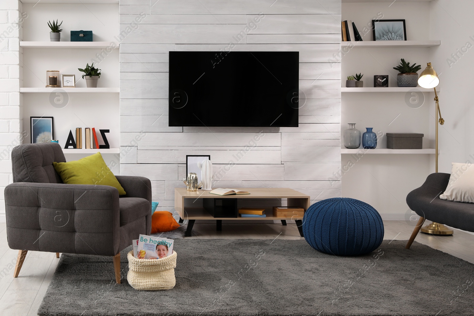 Photo of Cozy room interior with stylish furniture, decor and modern TV set