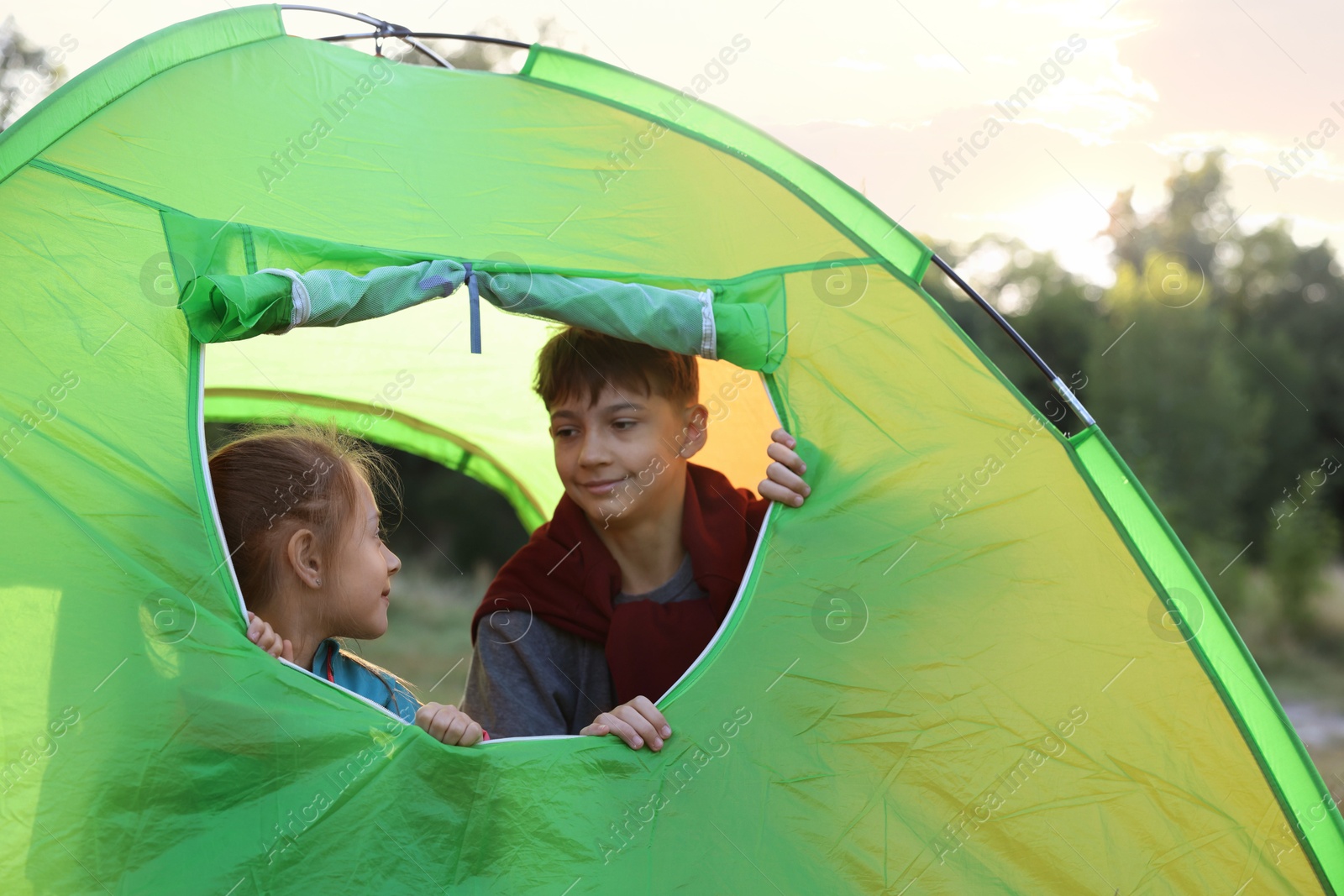 Photo of Brother and sister in camping tent outdoors