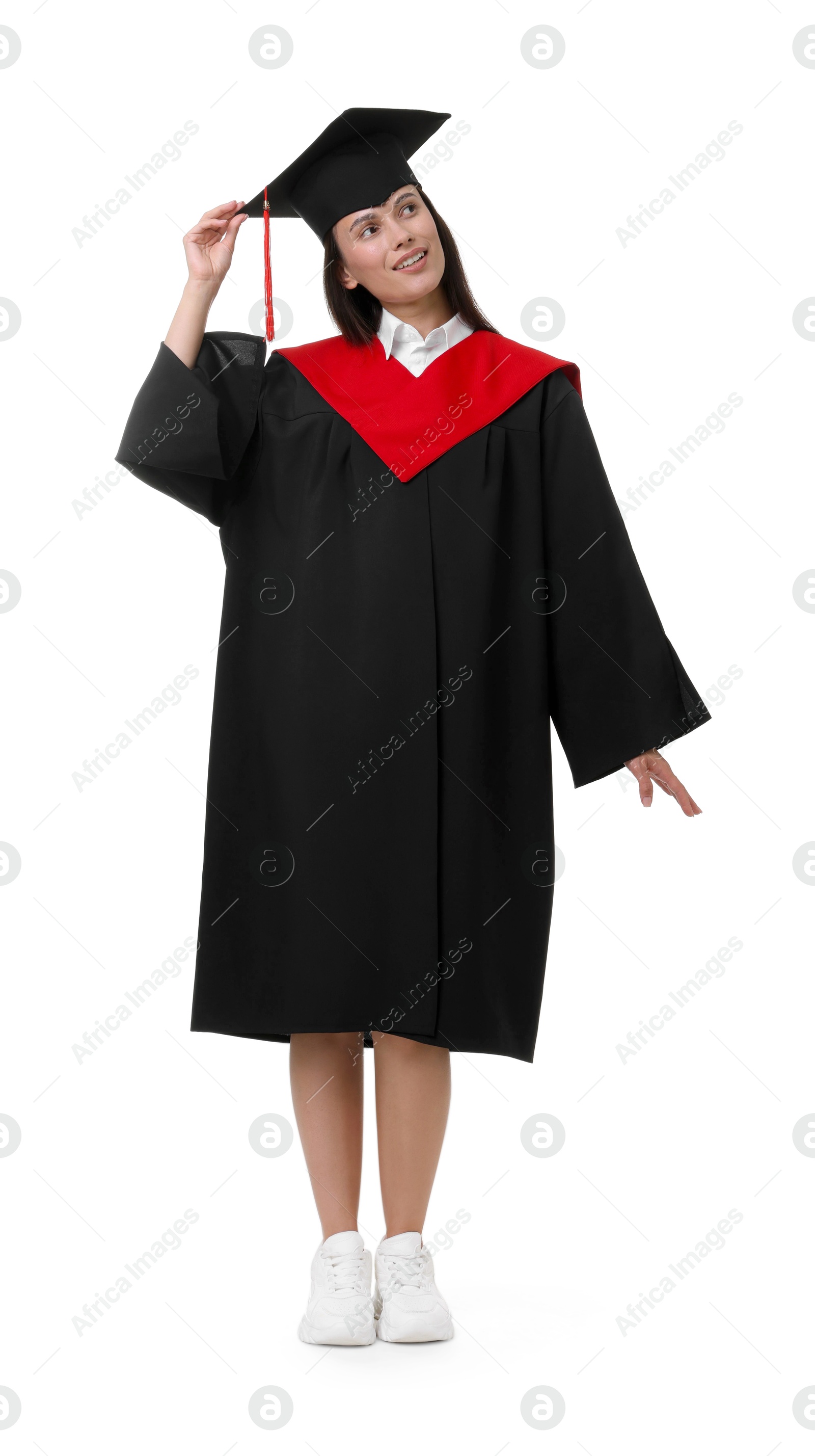 Photo of Happy young woman in graduation gown and mortarboard on white background