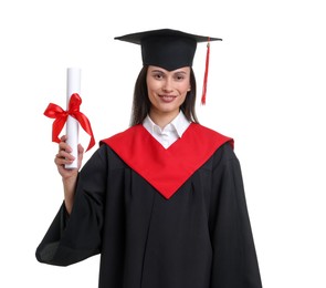 Photo of Portrait of happy young woman in graduation gown and mortarboard with diploma on white background