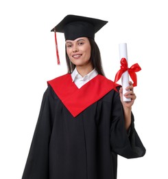 Photo of Portrait of happy young woman in graduation gown and mortarboard with diploma on white background