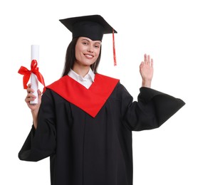Photo of Portrait of happy young woman in graduation gown and mortarboard with diploma on white background
