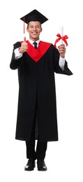 Photo of Portrait of happy young man in graduation gown and mortarboard with diploma showing thumbs up on white background