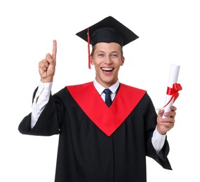 Photo of Portrait of happy young man in graduation gown and mortarboard with diploma on white background