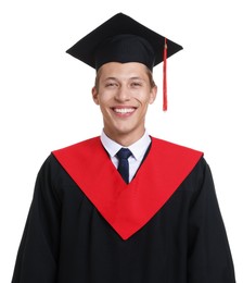 Photo of Portrait of young man in graduation gown and mortarboard on white background