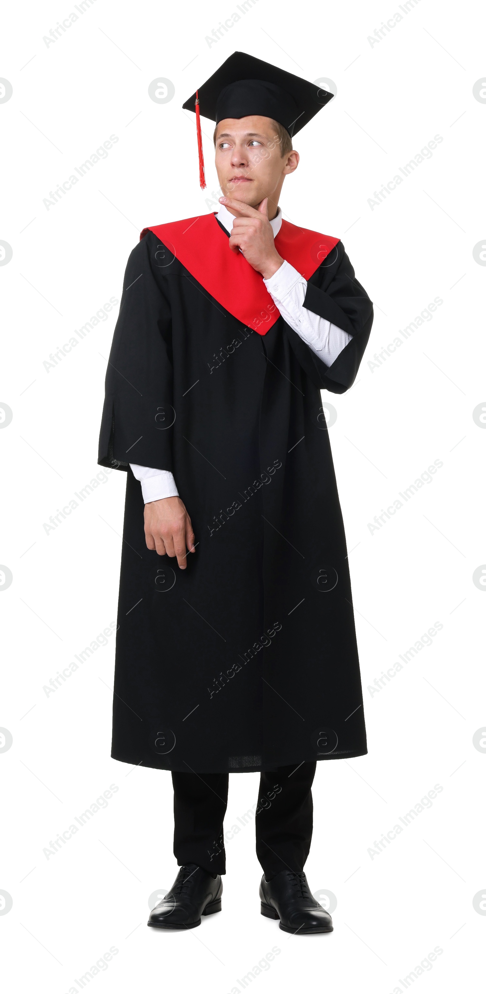 Photo of Thoughtful young man in graduation gown and mortarboard on white background
