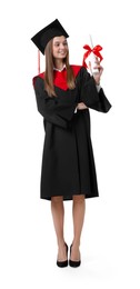 Photo of Happy young woman in graduation gown and mortarboard with diploma on white background