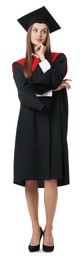 Photo of Thoughtful young woman in graduation gown and mortarboard on white background
