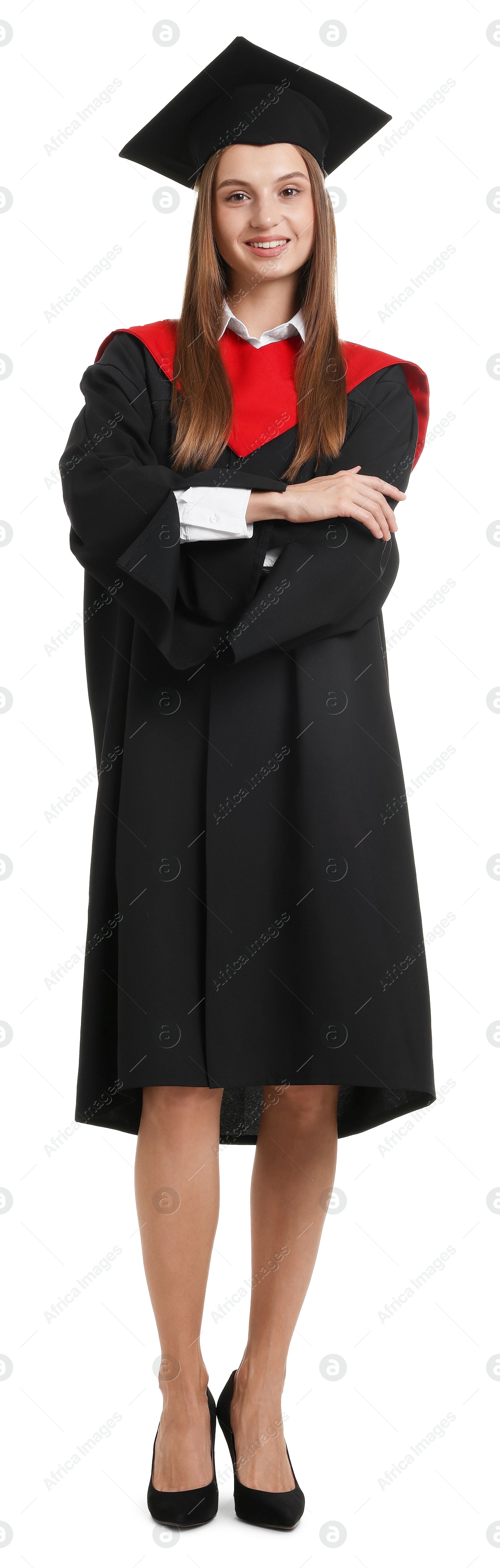 Photo of Happy young woman in graduation gown and mortarboard on white background