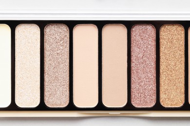 Photo of Beautiful eyeshadow palette on white table, top view