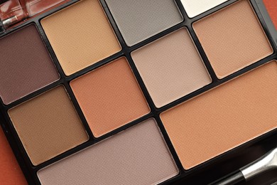 Photo of Beautiful eyeshadow palette on coral background, top view