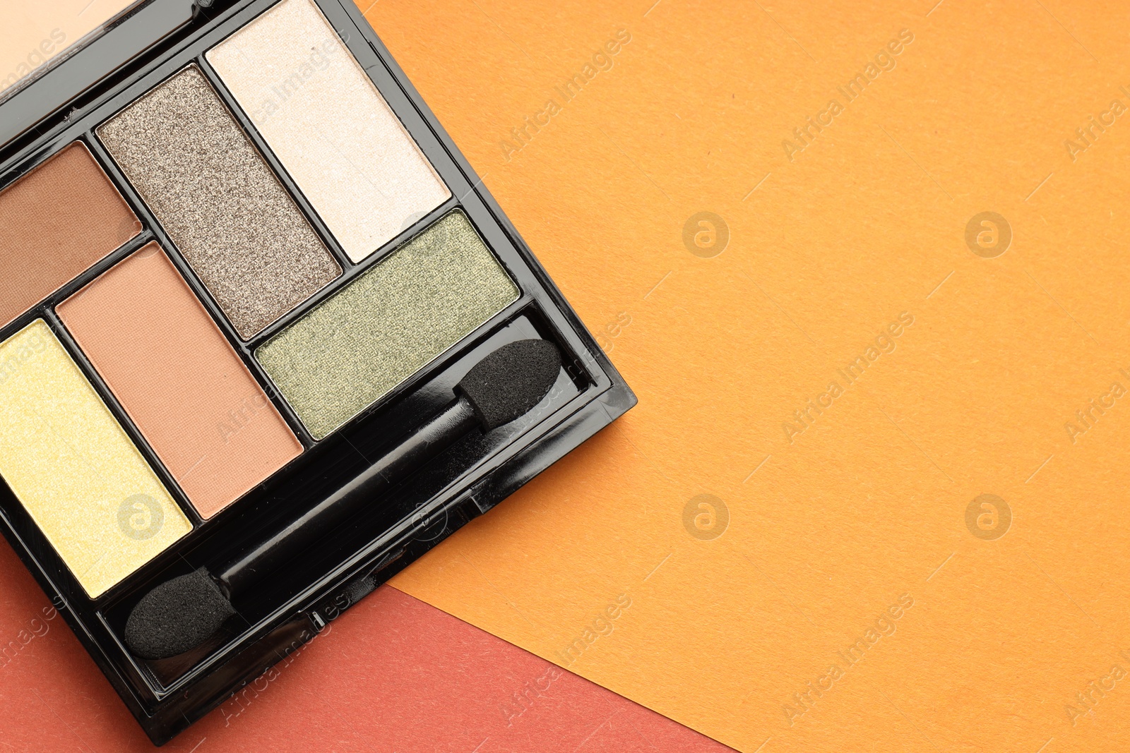 Beautiful eyeshadow palette and brush on color background, top view. Space for text Photo of Beautiful eyeshadow palette and brush on color background, top view. Space for text