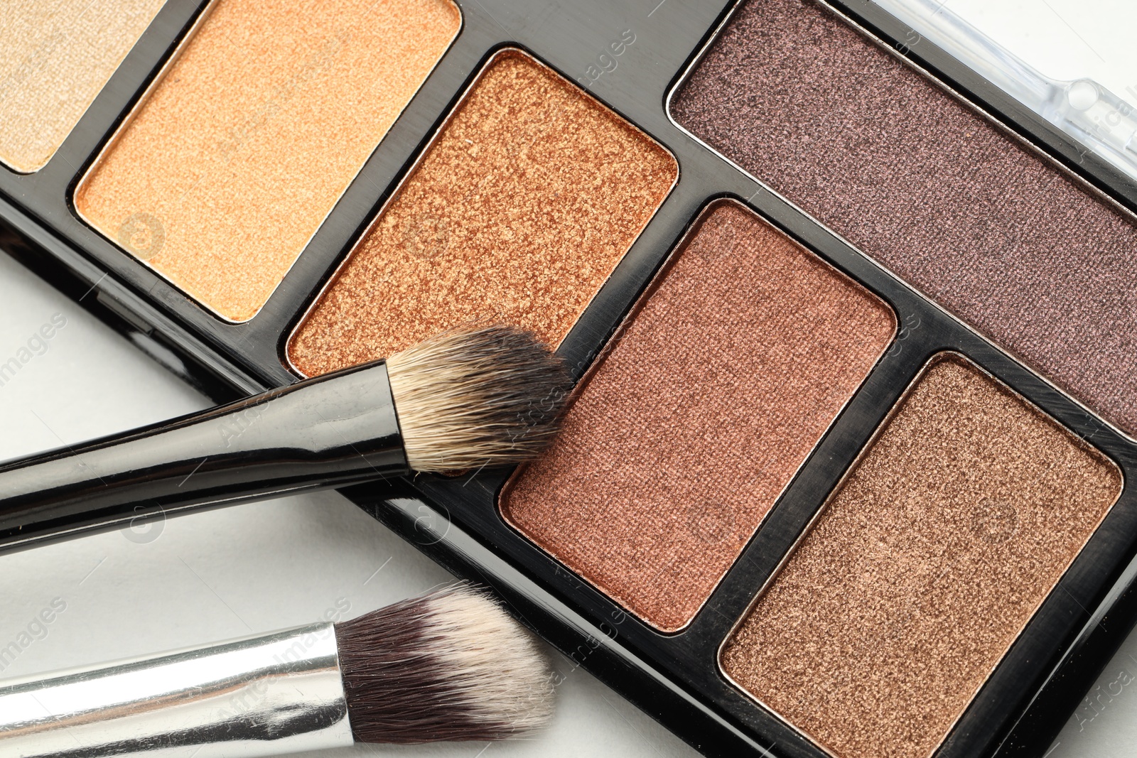 Photo of Beautiful eyeshadow palette and brushes on white background, top view