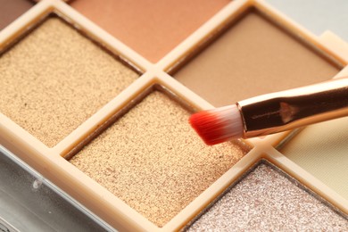 Photo of Beautiful eyeshadow palette and brush as background, closeup