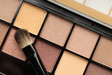 Photo of Beautiful eyeshadow palette and brush as background, top view