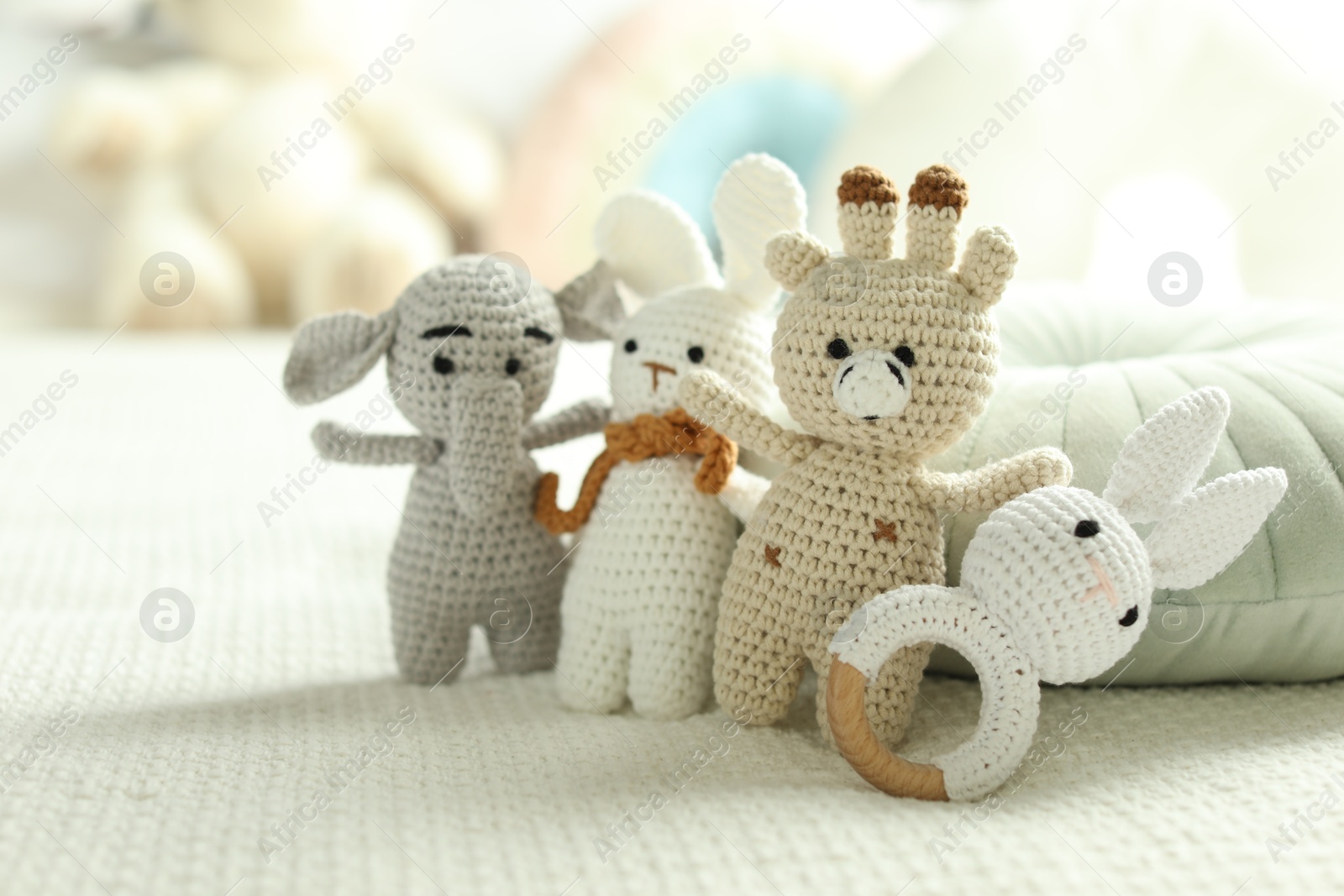 Photo of Different cute soft toys on bed, closeup