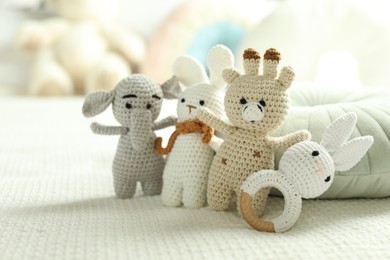 Photo of Different cute soft toys on bed, closeup