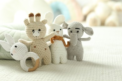 Photo of Different cute soft toys on bed, closeup