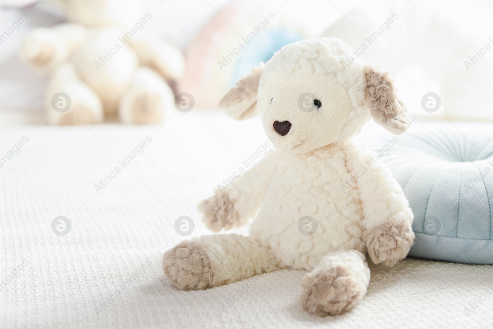 Photo of Cute soft toy sheep on bed, closeup. Space for text