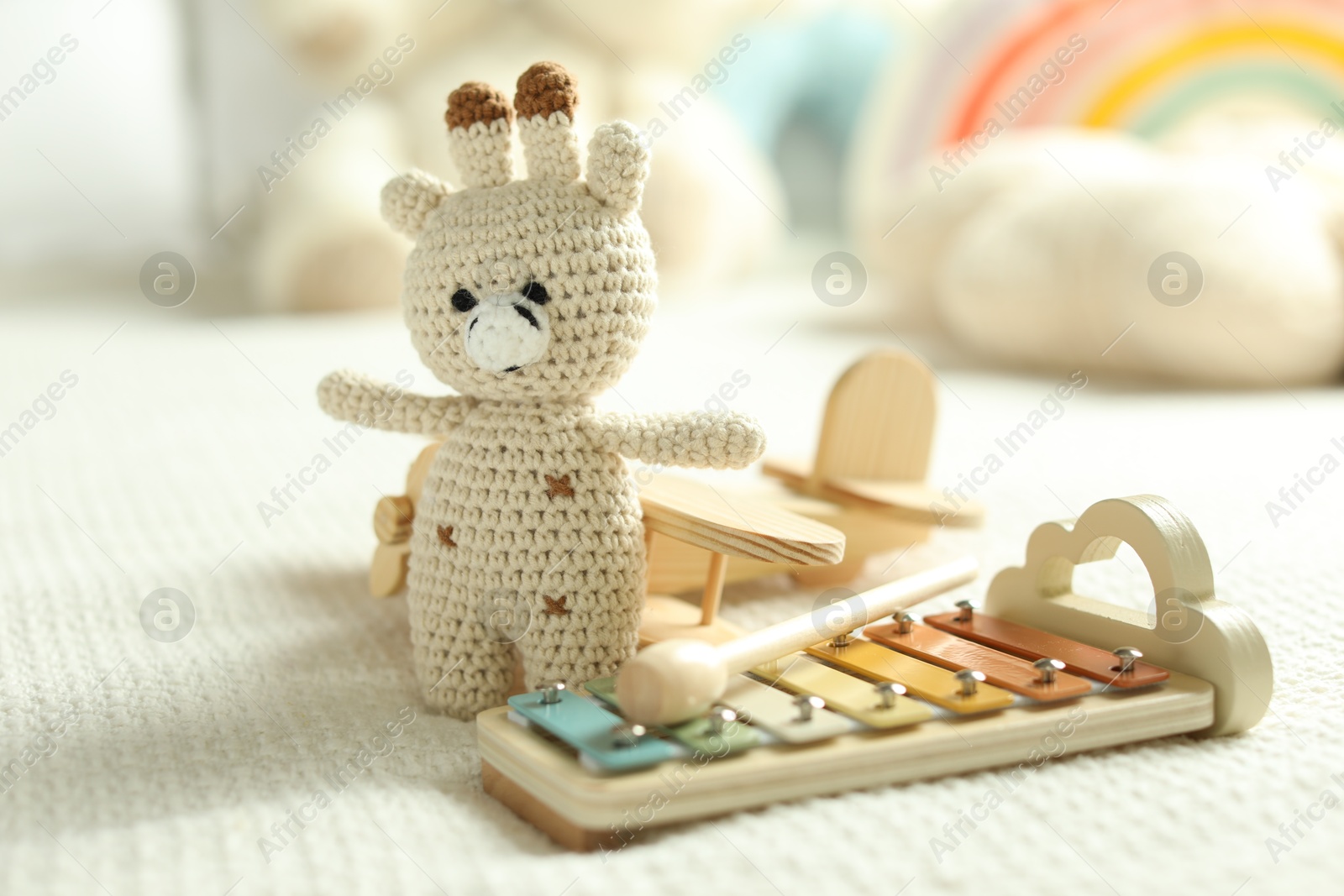 Cute giraffe, airplane and xylophone toys on bed, closeup Photo of Cute giraffe, airplane and xylophone toys on bed, closeup