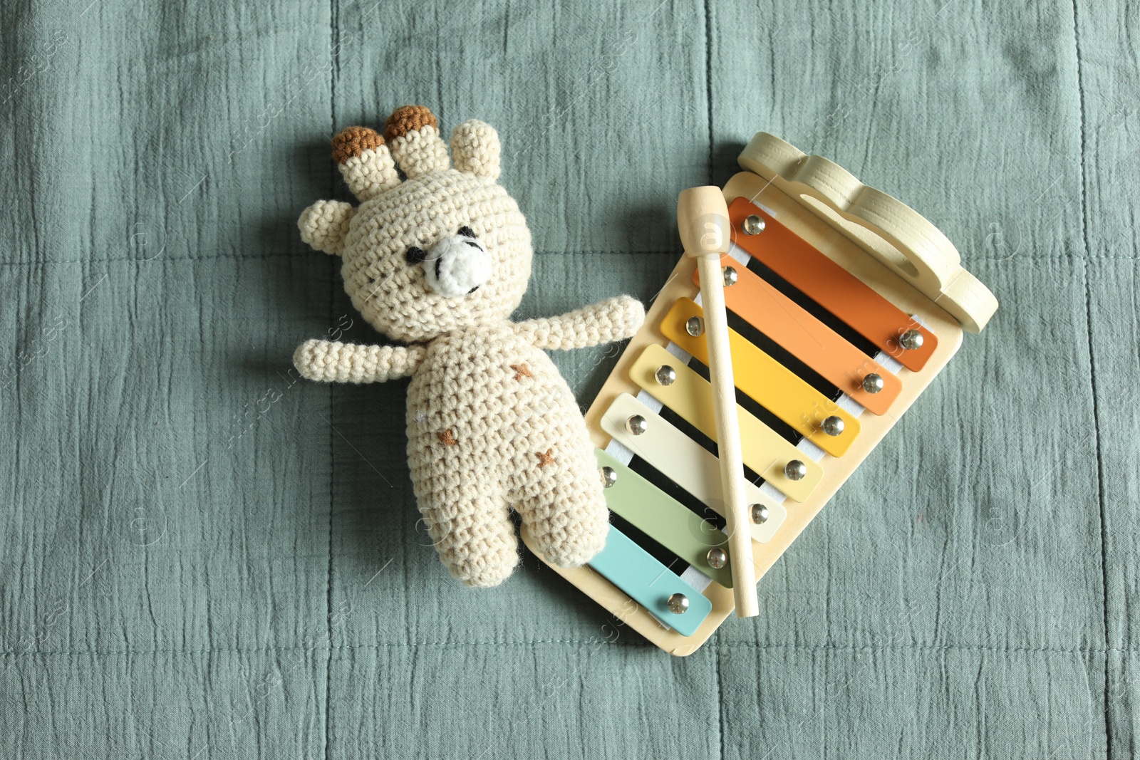 Photo of Cute giraffe and xylophone toys on grey fabric, top view