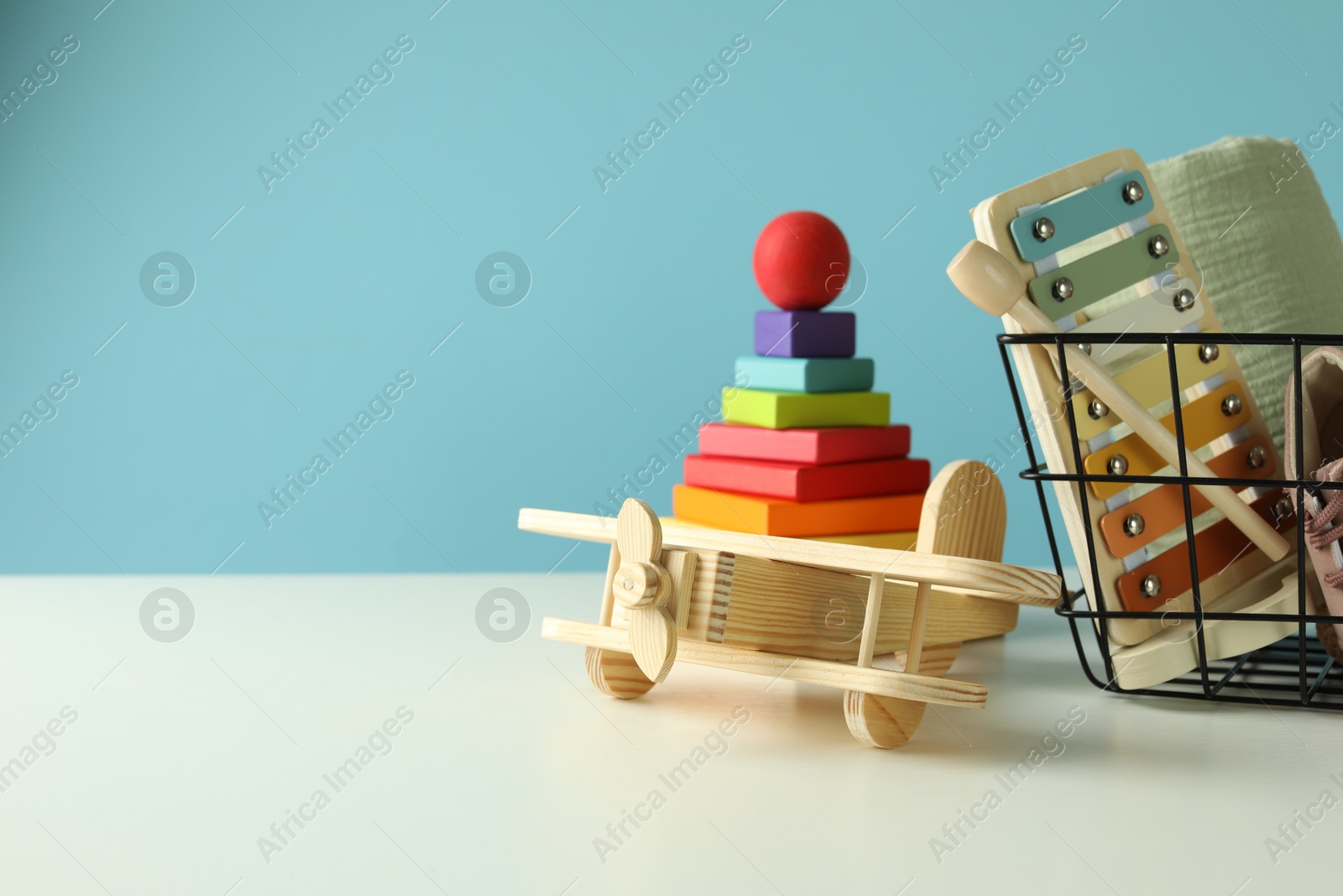 Photo of Different cute toys on white table against light blue background. Space for text