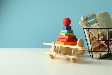 Photo of Different cute toys on white table against light blue background. Space for text