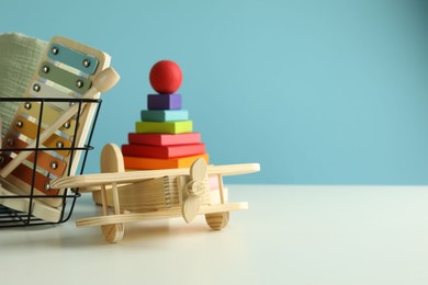 Photo of Different cute toys on white table against light blue background. Space for text