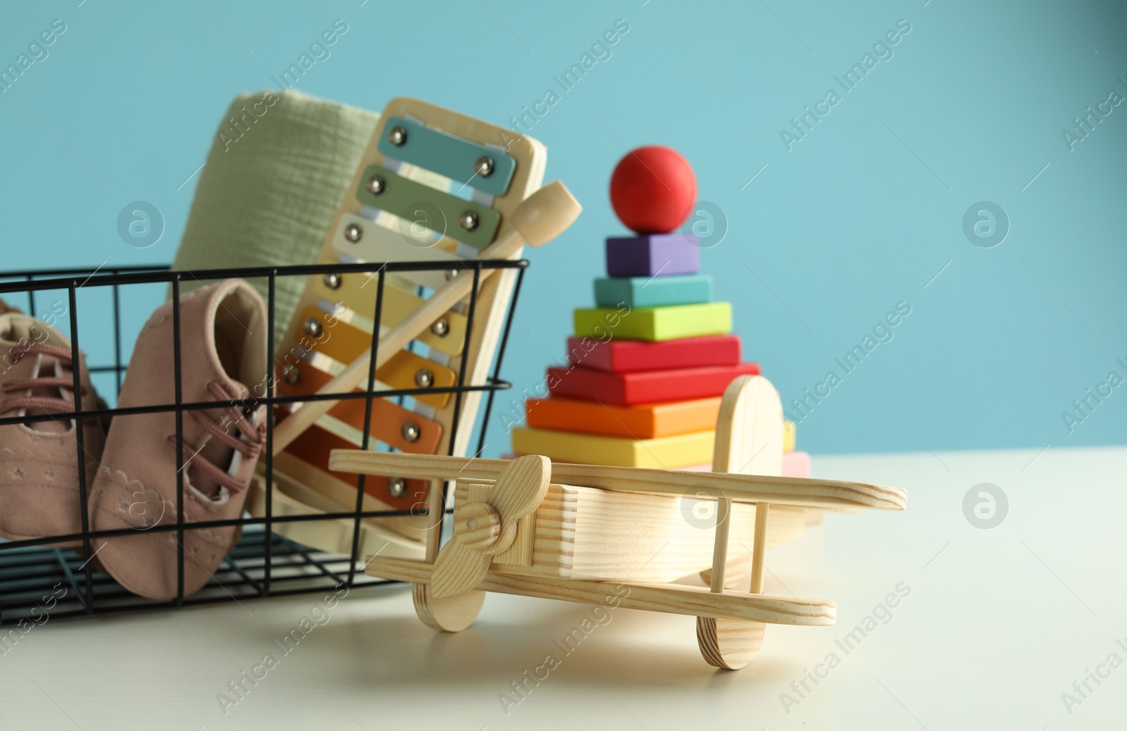 Photo of Different cute toys on white table against light blue background