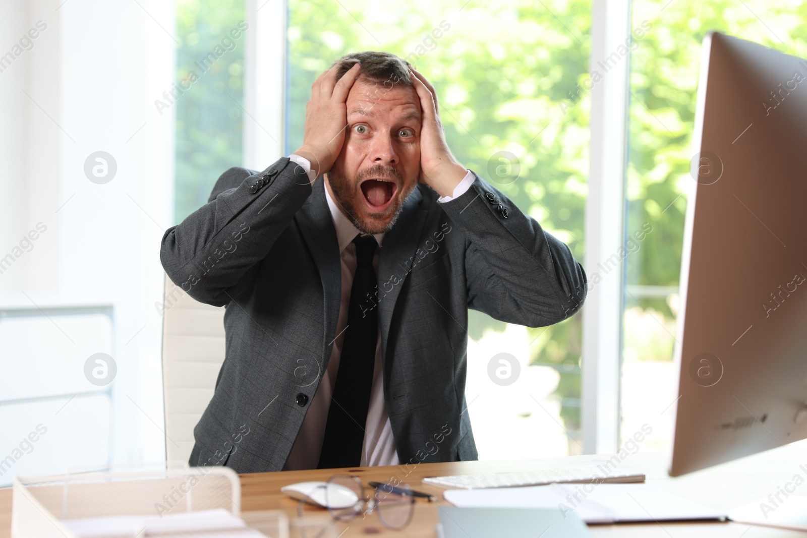 Photo of Businessman suffering from panic attack at workplace in office