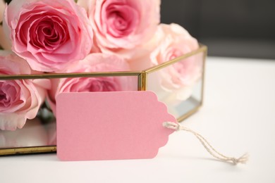 Photo of Blank card and roses on table indoors, closeup