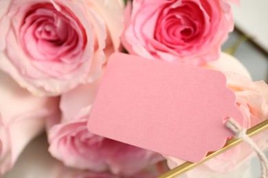 Photo of Blank card and roses on table indoors, closeup