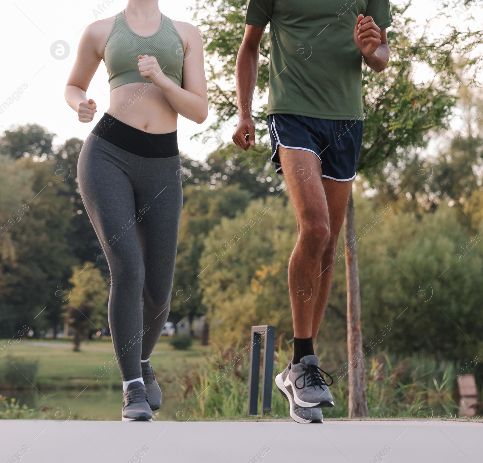 Photo of Couple in sneakers running outdoors, closeup. Healthy lifestyle