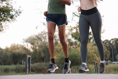 Photo of Couple running outdoors, closeup. Space for text