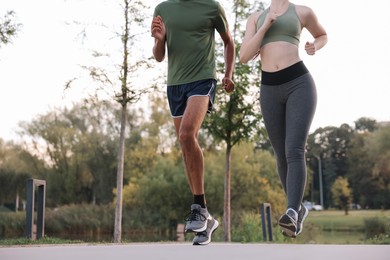 Photo of Couple running outdoors, closeup. Space for text