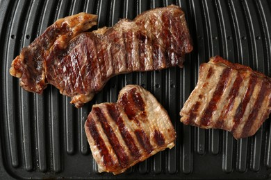 Photo of Electric grill with beef meat, top view