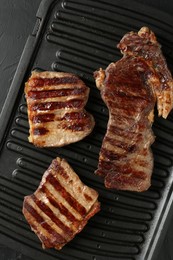 Photo of Delicious grilled beef meat on black table, top view