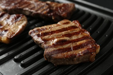 Photo of Electric grill with delicious beef meat, closeup