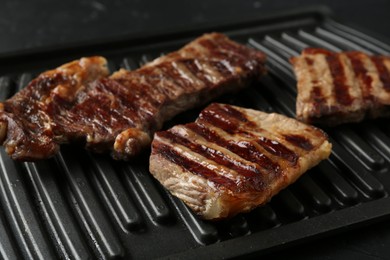 Photo of Delicious grilled beef meat on black table, closeup